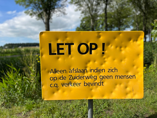 a yellow sign in a field