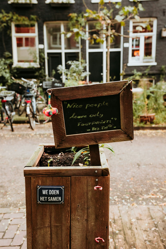 A wooden planter has a sign with an inspiring quote.