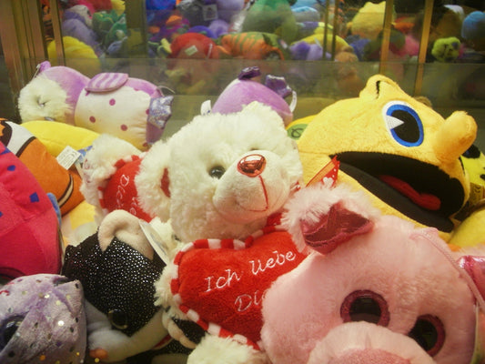 Plush toys including bears and pigs in a machine.