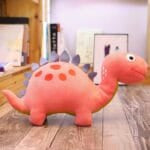 Grappige Roze Dinosaurus Knuffel met Grote Ogen en Glimlach De Knuffel